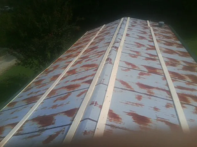 Rusted metal roof panels with new wood purlins before replacement — Storm Damage Roof Repair in Pocono Pines by Roofing Brothers