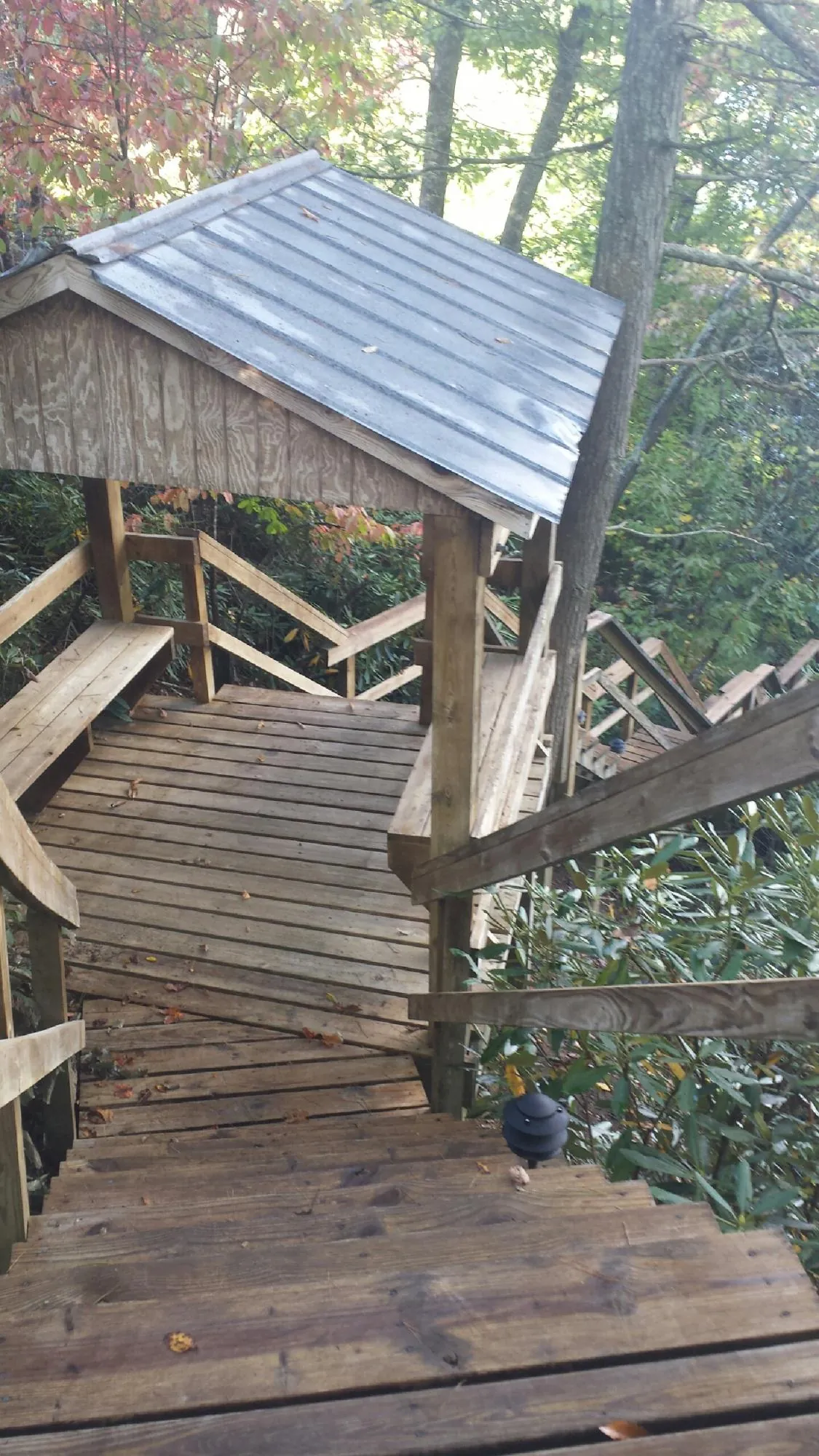 Metal roofed shelter over wooden steps on a wooded walkway — Skylight Repair & Installation work by our crew in Pocono Pines