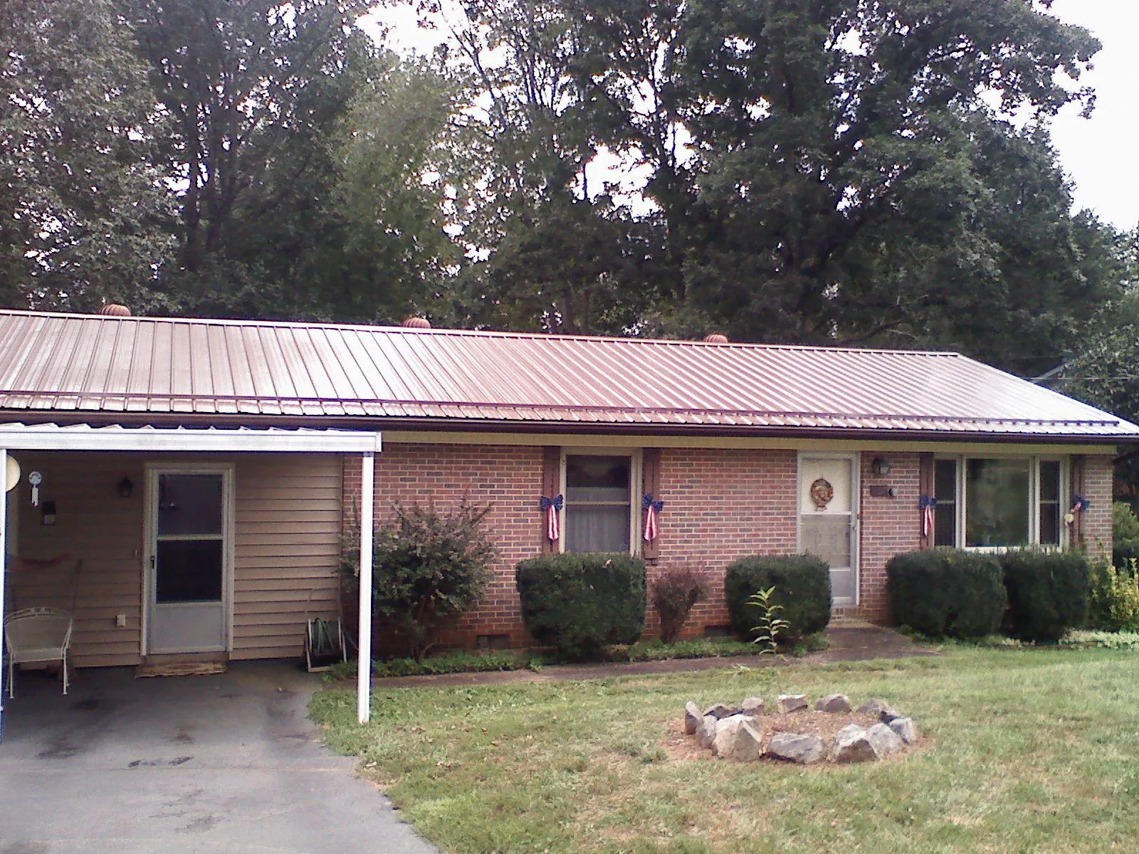 Bronze metal roof and carport on a brick ranch home — Roof Repair work by our crew in Pocono Pines